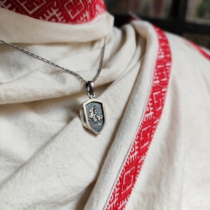 oxidized silver pendant with the coat of arms "The Chase", the national symbol of Belarus, Lithuania. The coat of arms depicts a knight on horseback, the knight is holding a sword and shield