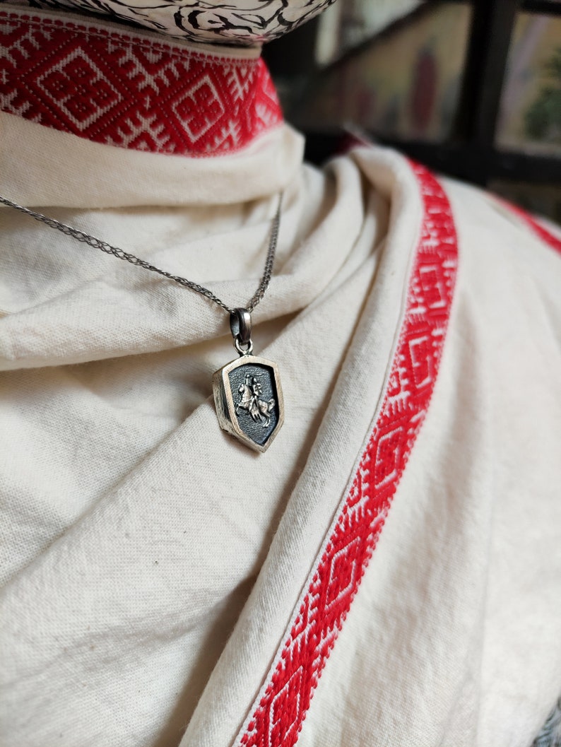 oxidized silver pendant with the coat of arms "The Chase", the national symbol of Belarus, Lithuania. The coat of arms depicts a knight on horseback, the knight is holding a sword and shield