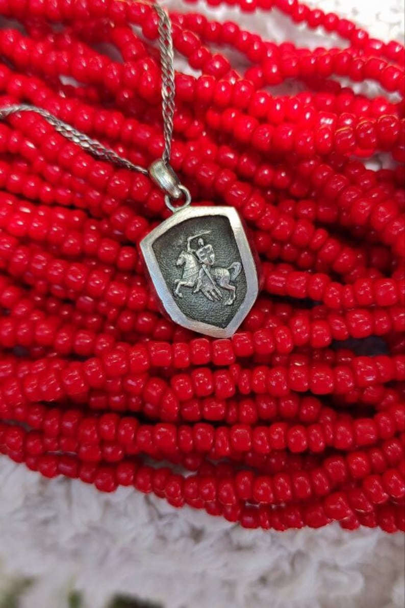 oxidized silver pendant with the coat of arms "The Chase", the national symbol of Belarus, Lithuania. The coat of arms depicts a knight on horseback, the knight is holding a sword and shield