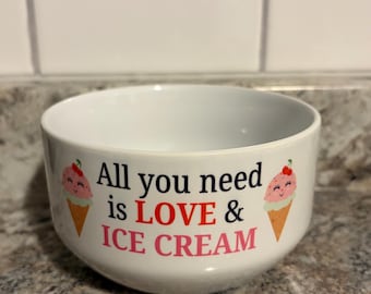 May include: White ceramic bowl with the text "All you need is LOVE & ICE CREAM" in black, red, and pink. The bowl features two ice cream cone illustrations with smiling faces and cherries.