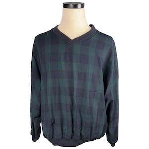 May include: A long-sleeved, plaid pullover shirt in a green and navy blue color scheme. The shirt features a V-neck collar and a gathered hem. The plaid pattern is a classic design, suitable for casual wear.