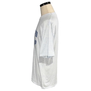 May include: A light gray t-shirt with a blue design on the front. The short-sleeved shirt is displayed on a mannequin. The fabric appears to be a soft, lightweight material.