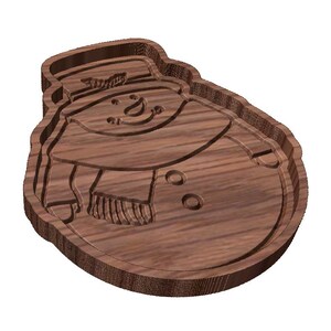 Peut inclure: Un plateau en bois en forme de bonhomme de neige avec des détails sculptés. Le plateau représente un bonhomme de neige portant un chapeau et une écharpe, avec des yeux, un sourire et des boutons sculptés. Le plateau est en bois brun foncé.