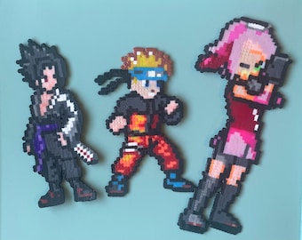 Può includere: Tre personaggi di pixel art realizzati con perline colorate. I personaggi sono Naruto, Sasuke e Sakura della serie anime Naruto. Naruto indossa un abito arancione e nero, Sasuke indossa un abito nero e viola e Sakura indossa un abito rosa e rosso.