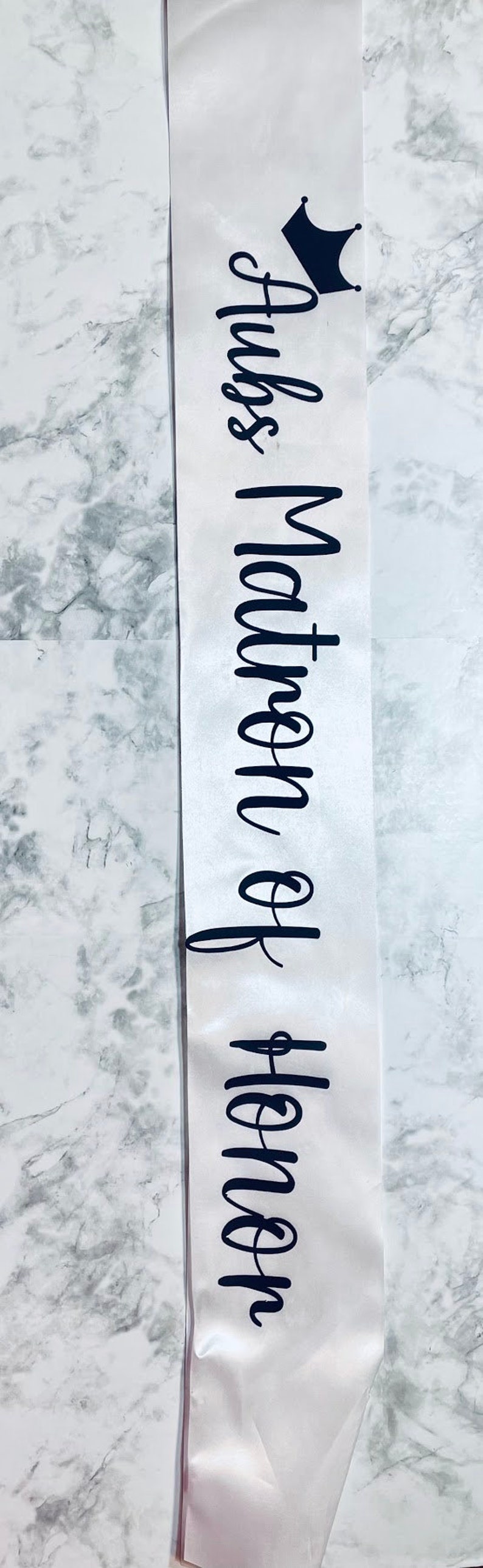 Puede incluir: Sash de sat&eacute;n blanco con texto negro que dice "Reina de las tinas" y un gr&aacute;fico de corona negra.