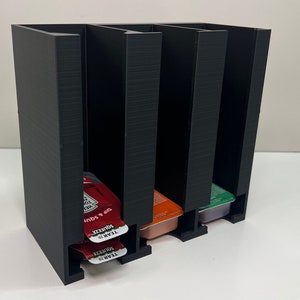Heinz ketchup 1 row and Chick-fil-a 2 rows single serve holder dispenser holds about 24-27 and is wall mountable.