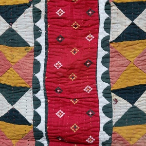 May include: A close-up of a red fabric with a diamond pattern. The fabric is surrounded by a white fabric with a scalloped edge and a green fabric with a scalloped edge.