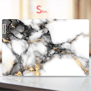 May include: White marble laptop skin with black and gold veins. The skin has the word "Lenovo" printed on the left side.