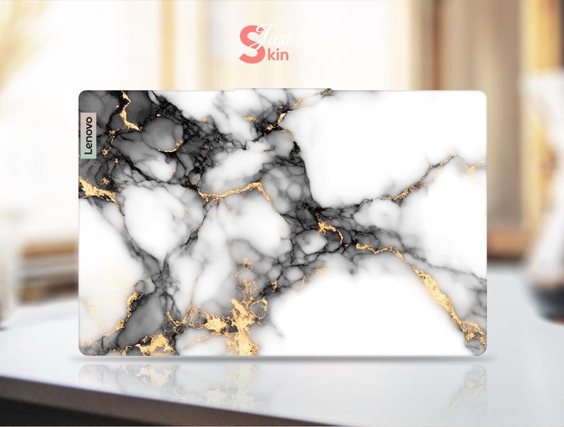 May include: White marble laptop skin with black and gold veins. The skin has the word "Lenovo" printed on the left side.