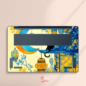 May include: Laptop skin featuring a whimsical design with a black cat perched on a blue structure, overlooking hanging lanterns and a crescent moon. The artwork incorporates yellow, blue, and orange hues, with floral accents and the text "Just kin".