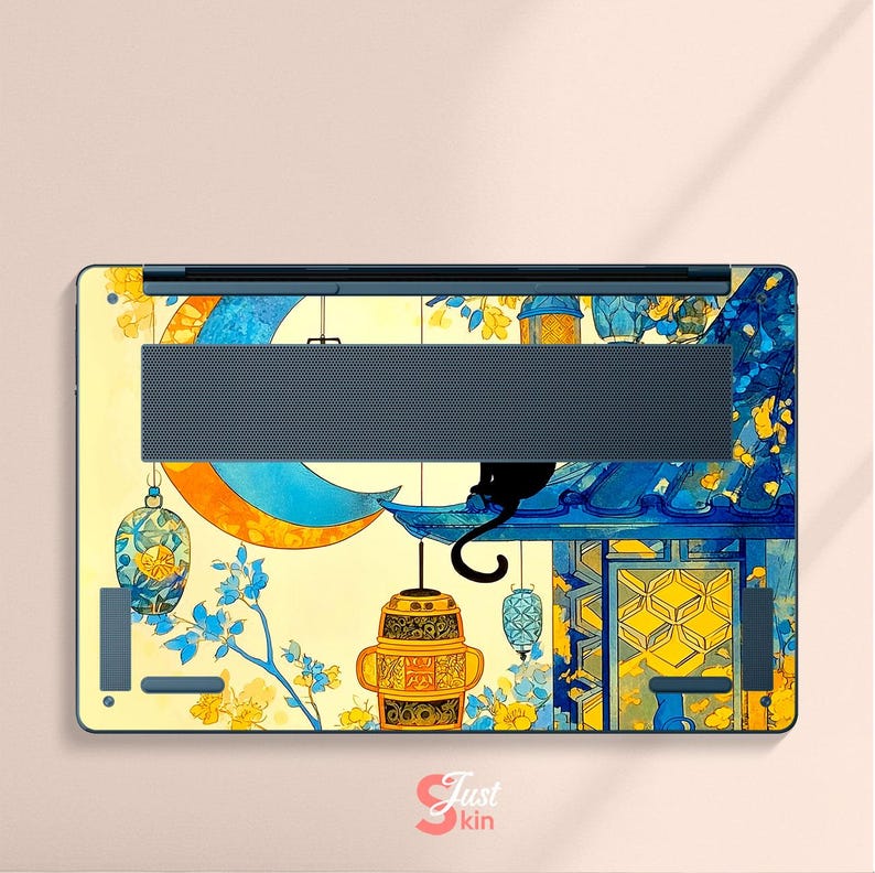 May include: Laptop skin featuring a whimsical design with a black cat perched on a blue structure, overlooking hanging lanterns and a crescent moon. The artwork incorporates yellow, blue, and orange hues, with floral accents and the text "Just kin".