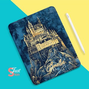 Puede incluir: Una ilustración de un castillo azul y dorado sobre un fondo azul oscuro. El castillo está rodeado de montañas y el nombre "Amelia" está escrito en letras doradas.