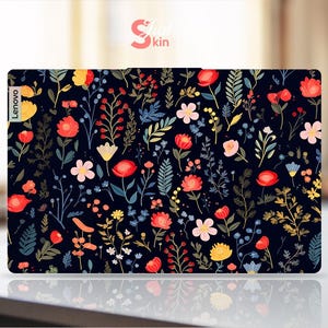 May include: A laptop skin with a floral pattern featuring red, pink, yellow, and blue flowers on a black background. The skin has the word "Lenovo" printed on the left side.