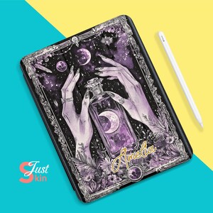 May include: A purple and black phone case with a mystical design featuring a crescent moon, stars, and a bottle of potion. The text "Amelia" is written in gold lettering.