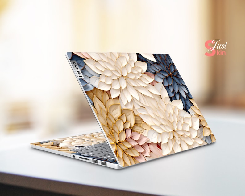 May include: A laptop computer with a floral design on the lid. The design features white, gold, and pink flowers with blue accents. The laptop is closed and the Lenovo logo is visible on the lid.