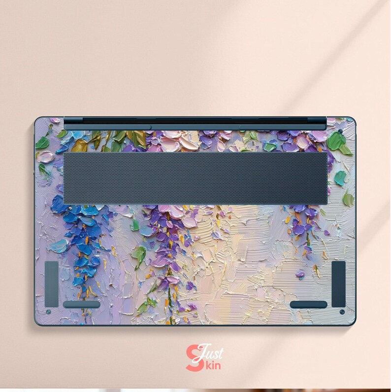 K&ouml;nnte beinhalten: Laptop-Skin mit einem strukturierten Blumendesign in Lila, Blau und Gr&uuml;n. Das Kunstwerk &auml;hnelt einem impressionistischen Gem&auml;lde mit sichtbaren Pinselstrichen. Die Haut hat einen dunkelgrauen L&uuml;ftungsbereich und den Text "Just kin".