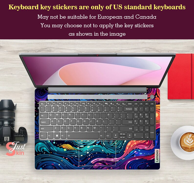 Puede incluir: Un port&aacute;til con una funda de teclado vibrante que muestra un dise&ntilde;o abstracto en tonos azules, morados y naranjas. El teclado est&aacute; a la vista y la pantalla del port&aacute;til muestra una imagen rosa claro y blanca. El texto indica que las pegatinas del teclado son solo para teclados estadounidenses.