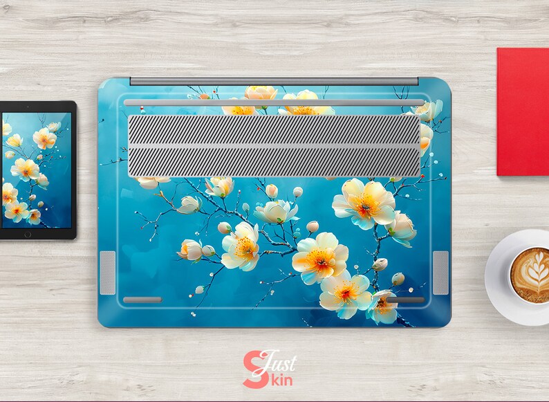 May include: A laptop skin with a floral design. The design features white flowers with yellow centers on a blue background. The laptop skin is made of a durable material and is easy to apply.