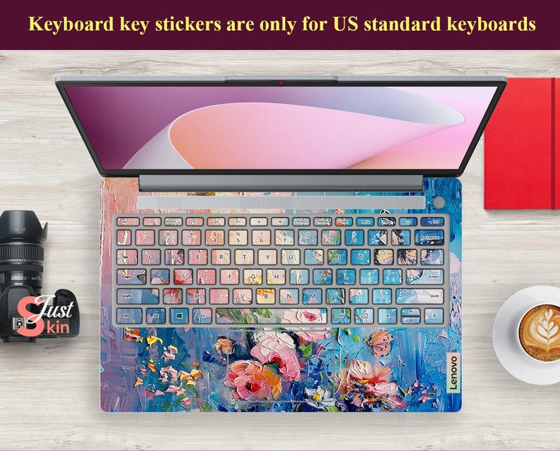 Puede incluir: Un ordenador port&aacute;til con una pegatina de teclado floral de colores. La pegatina presenta un dise&ntilde;o floral azul, rosa y verde con un efecto de pinceladas. El port&aacute;til es de la marca Lenovo.