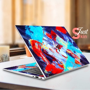May include: A laptop computer with a colorful abstract design on the lid. The design features blue, red, yellow, and white paint strokes. The laptop is open and the keyboard is visible.