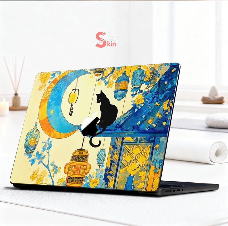 May include: Laptop skin featuring a whimsical illustration of a black cat perched on a rooftop under a crescent moon. The design incorporates yellow, blue, and white colors with hanging lanterns and floral accents. The text "Just Skin" is visible.