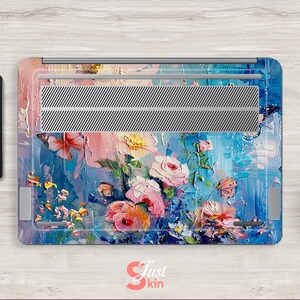 Puede incluir: Una piel para port&aacute;til con un dise&ntilde;o floral abstracto colorido. El dise&ntilde;o presenta flores rosas, azules y blancas sobre un fondo azul y blanco. La piel est&aacute; hecha de un material duradero y es f&aacute;cil de aplicar y quitar.