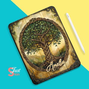 Könnte beinhalten: Eine braune Lederhülle für iPad mit einem keltischen Knotendesign und einer Baum-des-Lebens-Illustration. Die Hülle trägt eine goldene Inschrift mit dem Namen "Amelia".