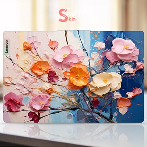 Könnte beinhalten: Eine Laptop-Haut mit einem floralen Design mit rosa, orangefarbenen und weißen Blumen auf blauem Hintergrund. Das Lenovo-Logo ist auf der linken Seite der Haut sichtbar.