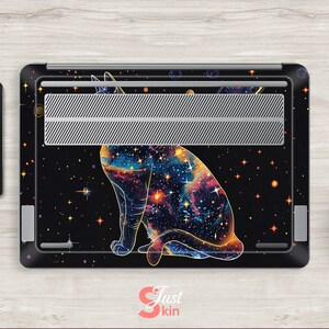 May include: A black laptop skin with a galaxy-themed cat design. The cat is outlined in gold and has a galaxy pattern inside. The background is black with gold stars.