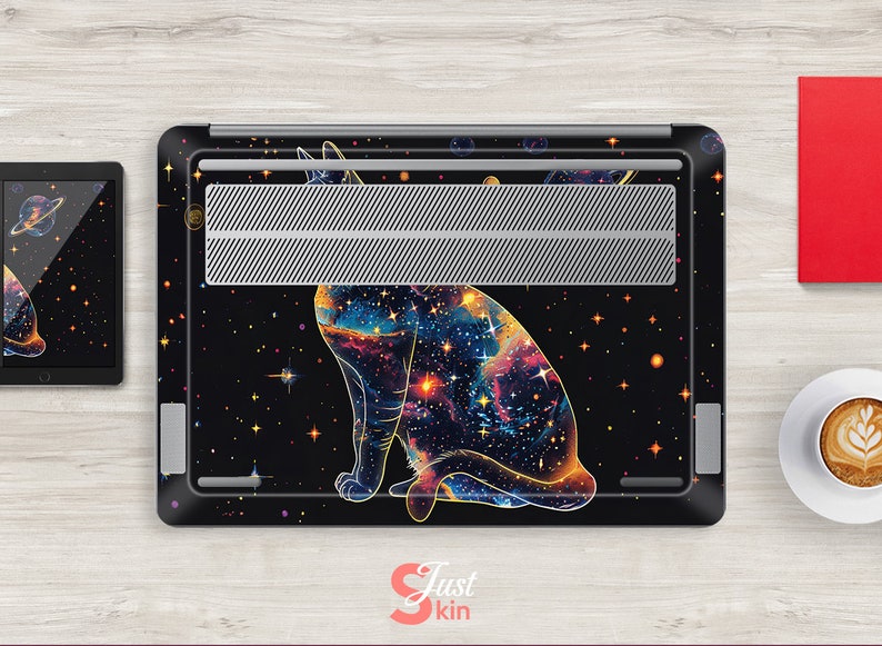 May include: A black laptop skin with a galaxy-themed cat design. The cat is outlined in gold and has a galaxy pattern inside. The background is black with gold stars.
