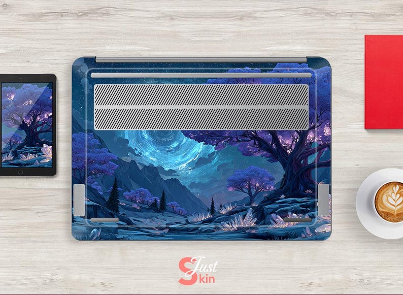 K&ouml;nnte beinhalten: Eine Laptop-H&uuml;lle mit einem Fantasy-Landschaftsdesign in Blau und Lila, mit einem gro&szlig;en Baum, Bergen und einem leuchtenden Himmel. Die H&uuml;lle hat ein silbernes L&uuml;ftungsgitter und befindet sich neben einem Tablet, einem roten Buch und einer Kaffeetasse.