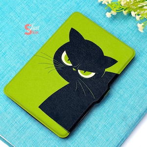 May include: A green and black tablet case featuring a black cat design with glowing green eyes. The cat's silhouette is set against a bright green background. The case is rectangular and appears to be made of a durable material.