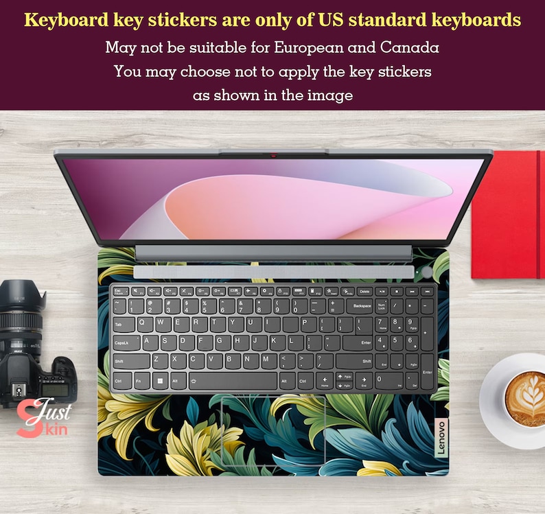 May include: A laptop keyboard with a floral design key sticker set. The keyboard is grey with black keys and the sticker set features a dark background with green, blue, and yellow floral patterns. The laptop is a Lenovo.