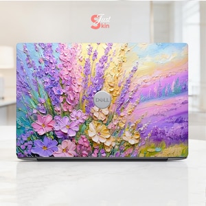 Puede incluir: Una funda para portátil con un vibrante diseño floral impresionista. La obra de arte muestra un campo de flores de lavanda, rosas y amarillas con un efecto texturizado y pintado. El logotipo de Dell es visible en el portátil.