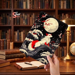 May include: Black tablet case featuring a Japanese-inspired design with a red and white fox, ocean waves, and a full moon. The case has a black background with red cherry blossoms. The text "Just kin" is visible.