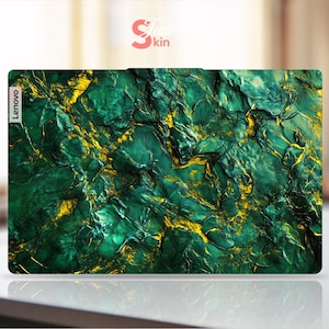 Puede incluir: Una funda para portátil con un diseño abstracto texturizado en tonos verdes y dorados. El logotipo de Lenovo es visible en la esquina superior izquierda. La funda tiene forma rectangular y probablemente está hecha de un material duradero.