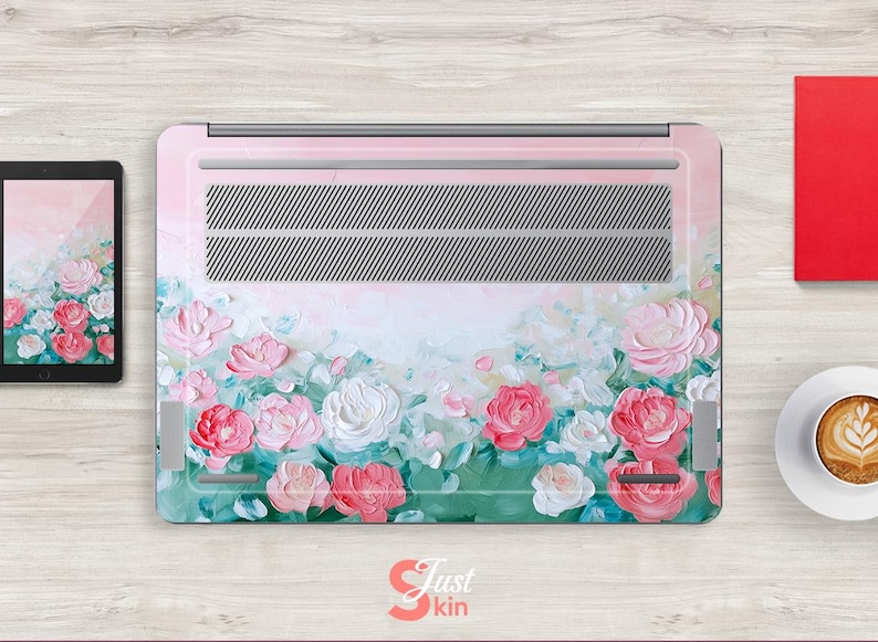 Peut inclure: Peau de protection pour ordinateur portable avec un motif floral compos&eacute; de fleurs roses, blanches et vertes sur un fond rose clair. Le motif est une peinture de style aquarelle.