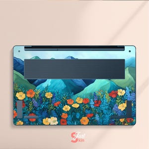 Pode incluir: Skin para laptop com um design vibrante de flores e montanhas. A obra de arte apresenta flores coloridas em tons de amarelo, laranja e vermelho, em um cen&aacute;rio de montanhas azuis e c&eacute;u claro. A skin &eacute; projetada para um laptop.