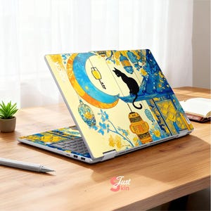 May include: A laptop with a decorative cover featuring a black cat silhouette perched on a crescent moon. The design includes hanging lanterns, blue and yellow floral accents, and the text "Just kin".