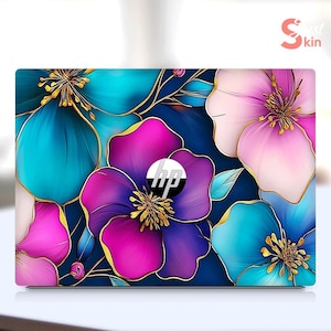 May include: Laptop skin with a floral design featuring blue, pink, and purple flowers with gold accents. The HP logo is visible in the center of the design.