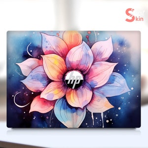 May include: A laptop skin featuring a watercolour design of a pink and blue flower on a dark blue background. The flower has a white centre with the HP logo.