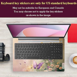 Puede incluir: Un teclado de port&aacute;til con una pegatina con dise&ntilde;o de mariposa. La pegatina es de color rosa claro y morado con una mariposa en el centro. El teclado es negro con letras blancas. El port&aacute;til es un Lenovo.