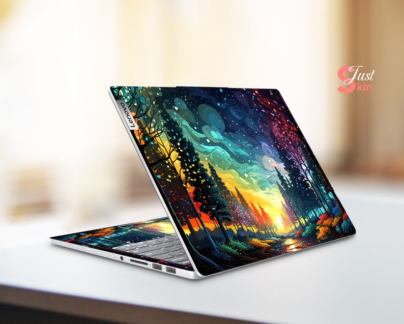 K&ouml;nnte beinhalten: Ein Laptop mit einem farbenfrohen abstrakten Design einer Waldszene mit Sonnenuntergang. Das Design zeigt eine Vielzahl von Farben, darunter Blau, Gr&uuml;n, Gelb, Orange und Rot. Der Laptop ist ge&ouml;ffnet und der Bildschirm ist sichtbar. Der Laptop hat das Lenovo-Logo an der Seite.