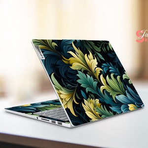 May include: A laptop computer with a dark blue and green floral design on the lid. The design features intricate leaves and swirls. The laptop is closed and the Lenovo logo is visible on the lid.