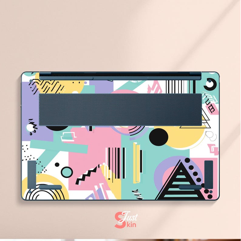 May include: Laptop skin with a colorful geometric design. The skin features a mix of shapes, including triangles, circles, and lines, in pastel colors like pink, blue, and yellow. The text "Just Skin" is visible in the bottom right corner.