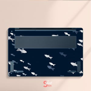May include: A navy blue laptop skin featuring a pattern of white and gray fish swimming across the surface. The skin has a dark gray vent area and is designed to fit a laptop. The logo "Just Skin" is visible in the bottom right corner.