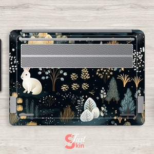 May include: Laptop skin with a whimsical forest design featuring a white rabbit, trees, and foliage in shades of blue, gold, and white against a dark background. A tablet with a matching design is also visible.