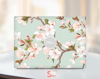 May include: A laptop skin with a floral design featuring pink and white flowers on a light blue background. The Dell logo is visible in the centre of the skin.