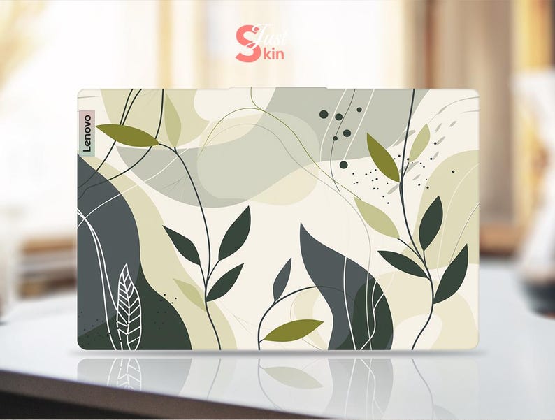 May include: A laptop skin with an abstract design featuring green leaves and white lines on a cream background. The skin has the word "Lenovo" printed on the left side.