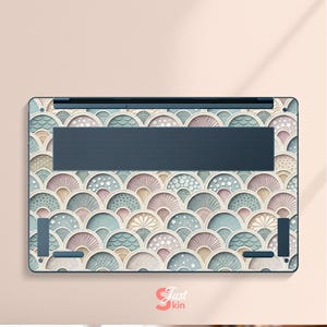 Puede incluir: Skin para port&aacute;til con un patr&oacute;n repetitivo en forma de abanico en colores pastel de azul, rosa y beige. La skin tiene un &aacute;rea de ventilaci&oacute;n azul oscuro y el texto "Just Skin" en la esquina inferior derecha.